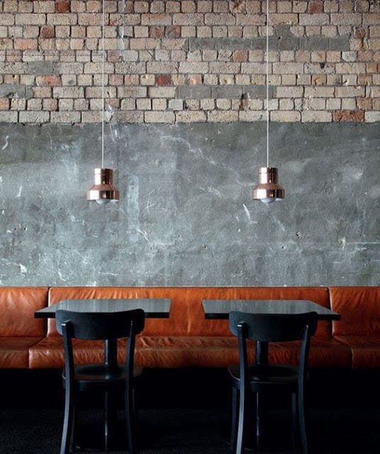 Leather booth seating against an unfinished wall