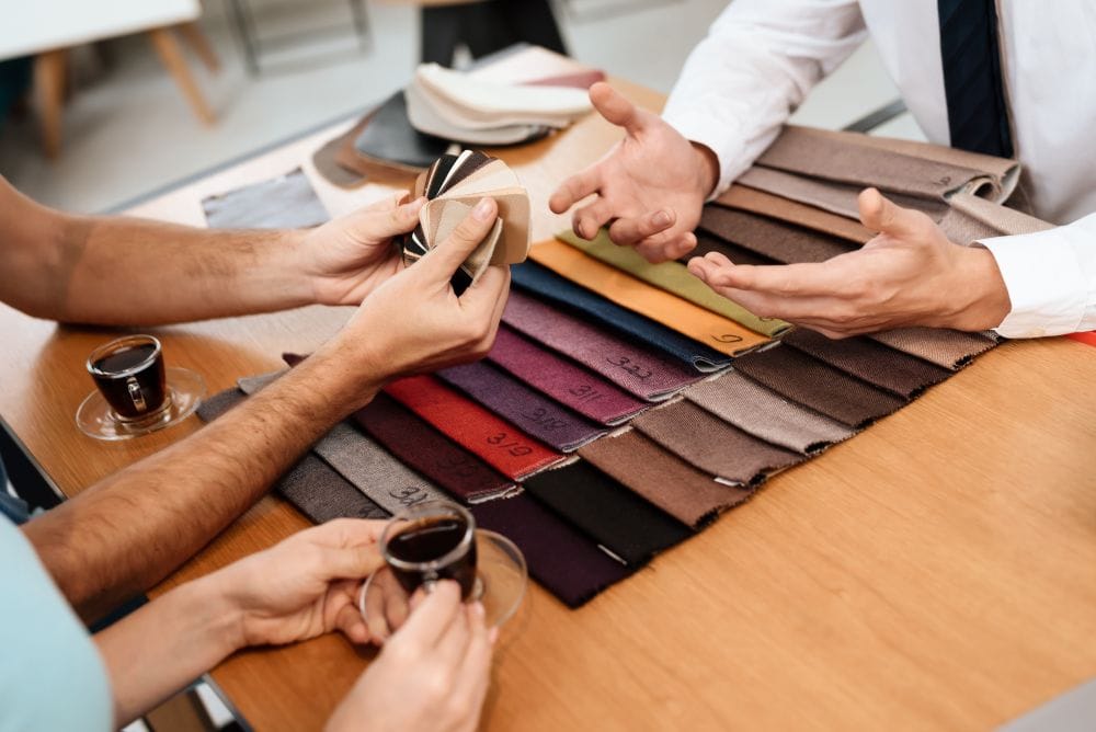 People reviewing leather and material swatches at a table