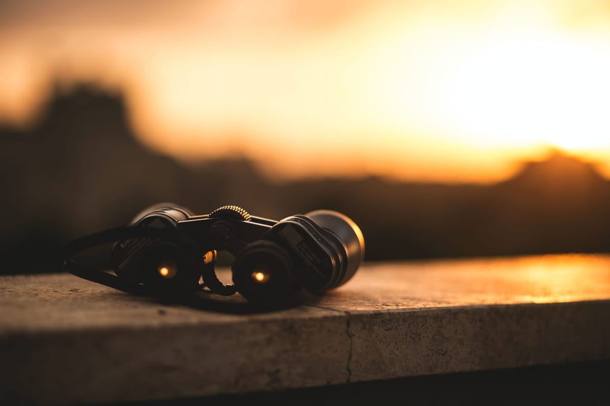 Binoculars resting against a sunset