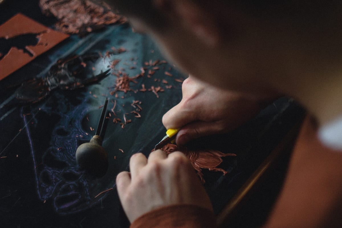Craftsperson carving a detailed material surface