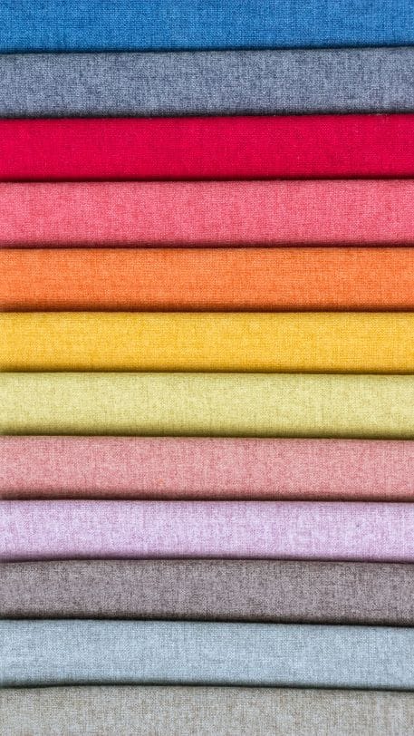A stack of colourful upholstery fabric samples