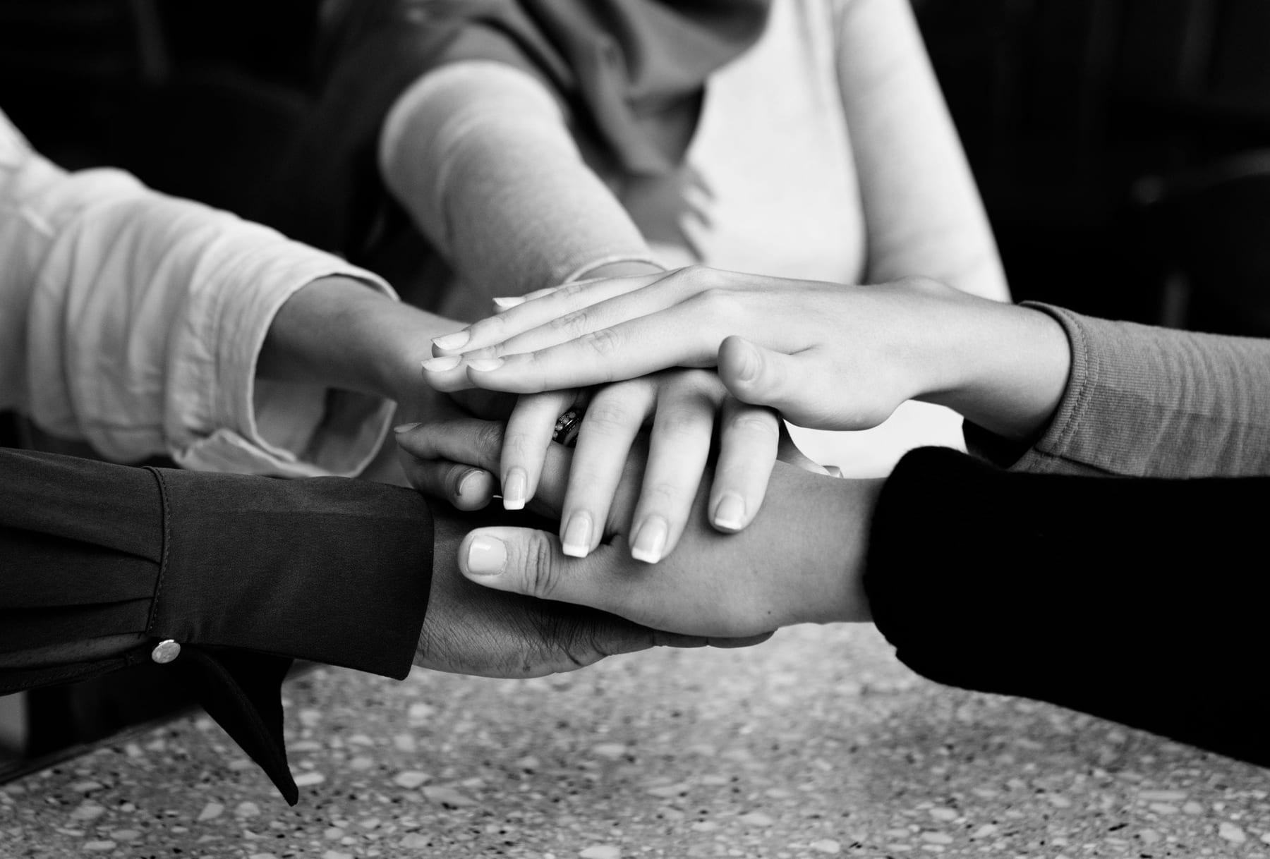 A group of people stacking their hands