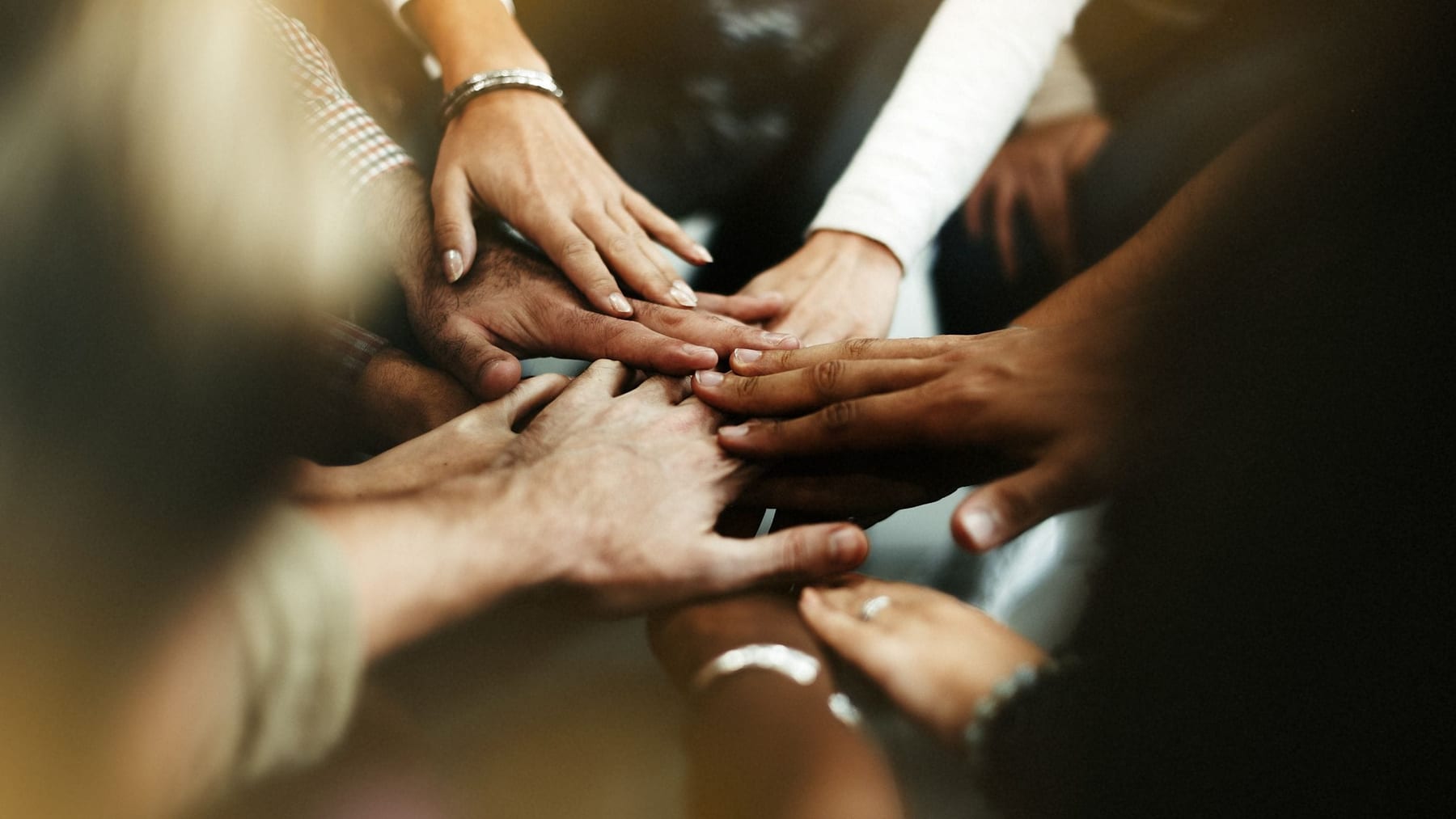 A diverse group joining hands