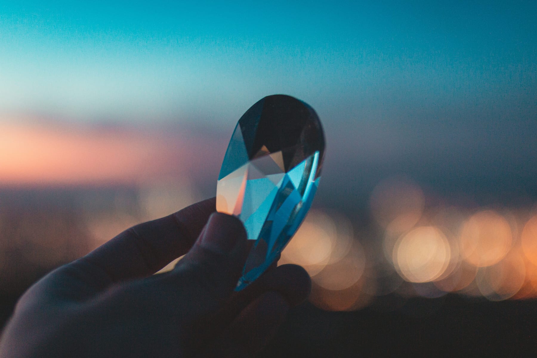 A hand holding a faceted glass object